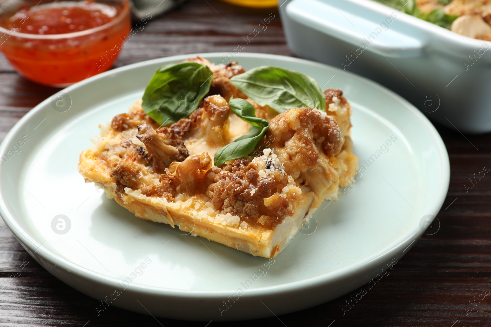 Photo of Tasty baked cauliflower and basil on wooden table, closeup