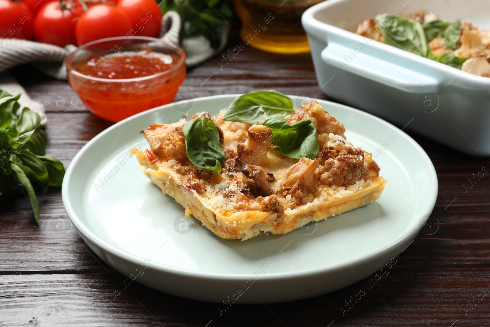 Photo of Tasty baked cauliflower and basil on wooden table, closeup