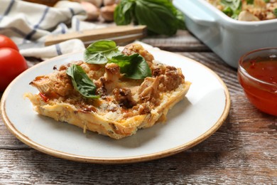 Photo of Tasty baked cauliflower and basil on wooden table, closeup