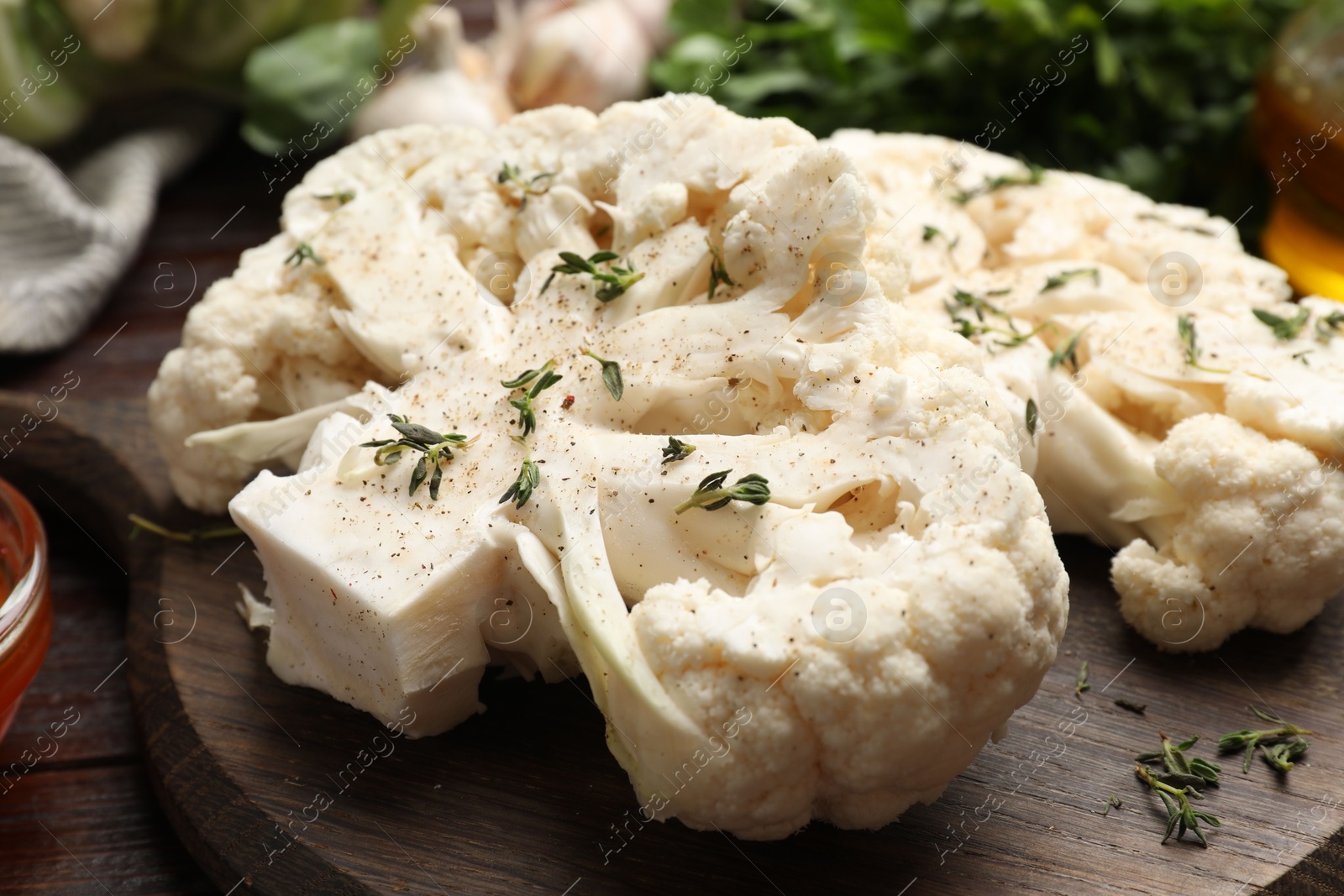 Photo of Uncooked cauliflower steaks with spices on table, closeup