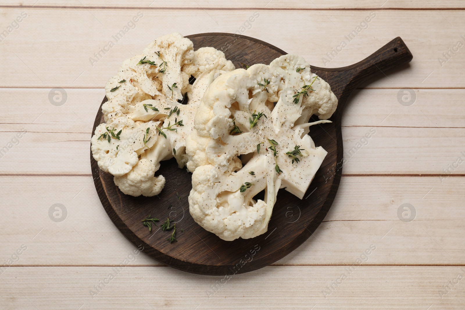 Photo of Uncooked cauliflower steaks with spices on wooden table, top view