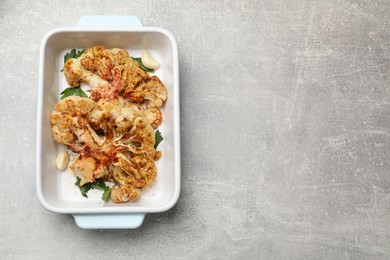 Photo of Delicious baked cauliflower steaks on grey table, top view. Space for text