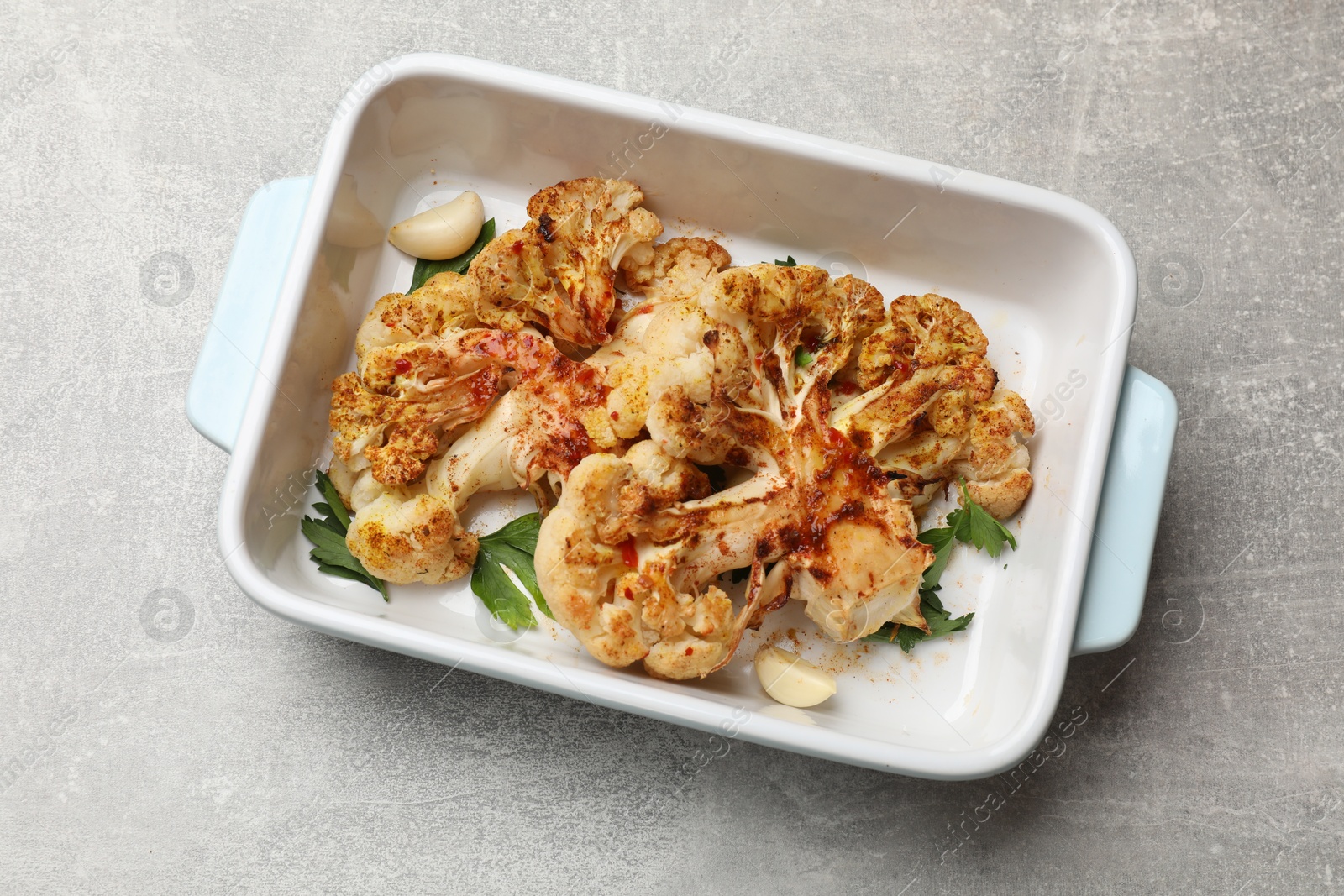 Photo of Delicious baked cauliflower steaks on grey table, top view