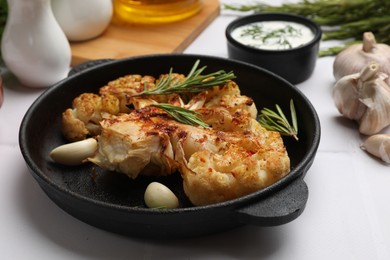 Photo of Delicious baked cauliflower steaks served on white tiled table, closeup