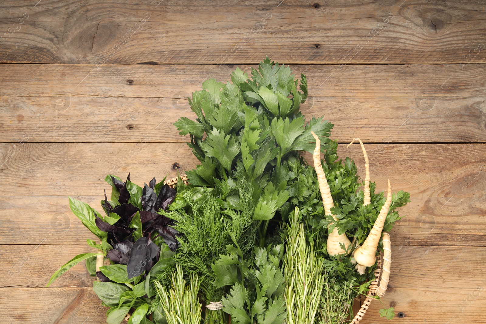 Photo of Different aromatic herbs in wicker basket, top view