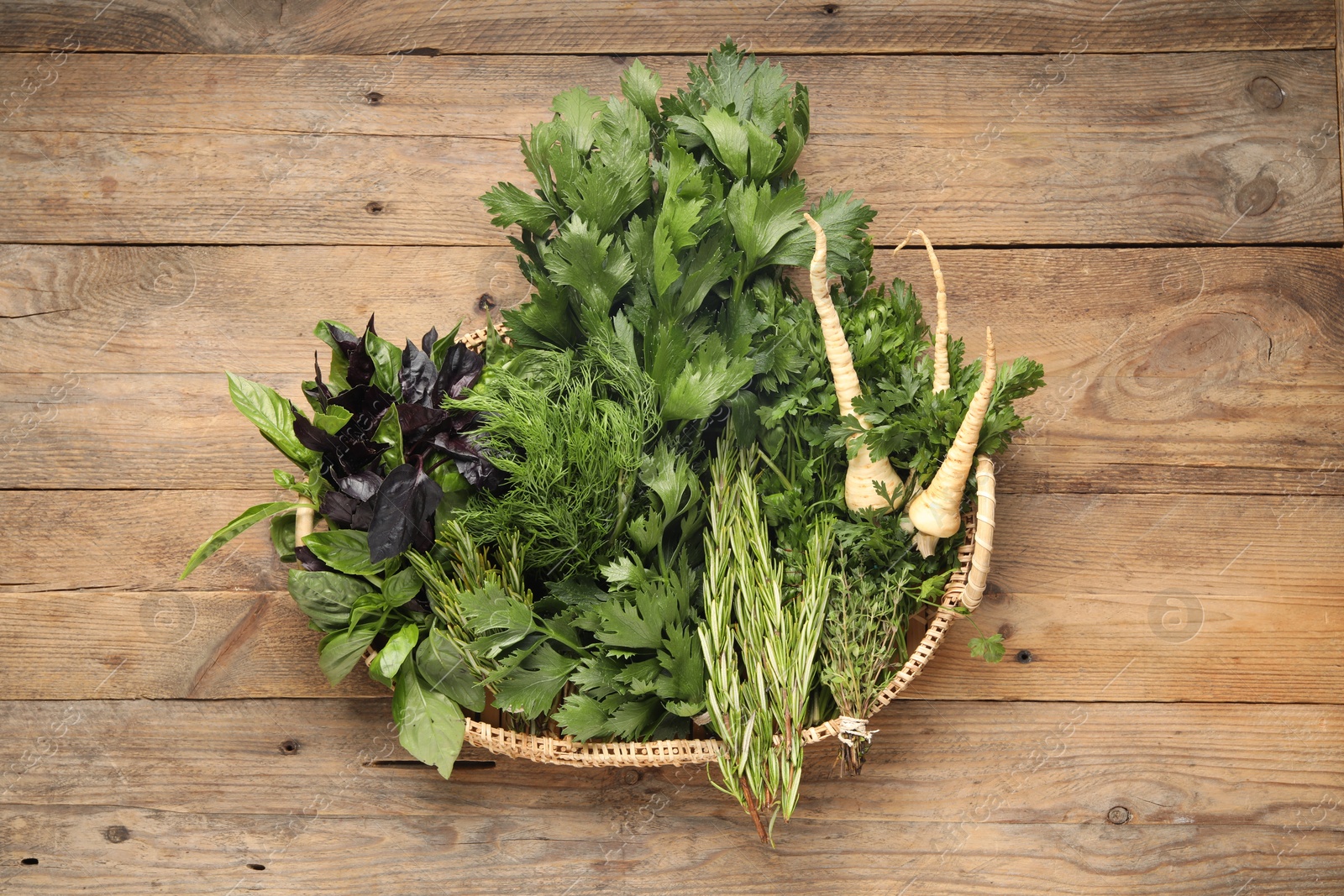 Photo of Different aromatic herbs in wicker basket, top view