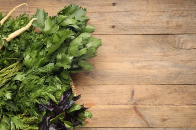 Photo of Different aromatic herbs on wooden table, top view. Space for text