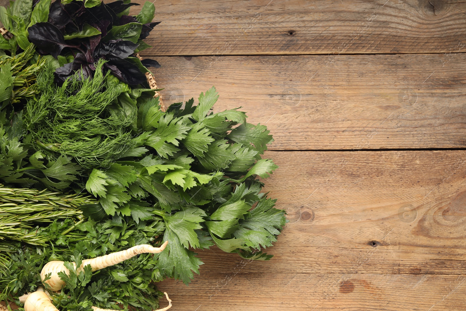 Photo of Different aromatic herbs on wooden table, top view. Space for text