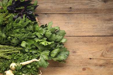 Photo of Different aromatic herbs on wooden table, top view. Space for text