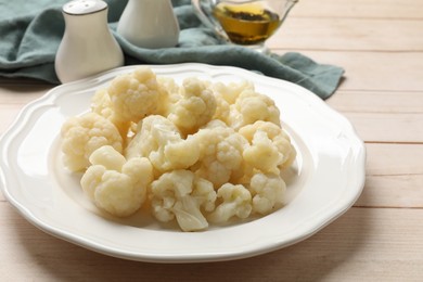 Photo of Tasty cooked cauliflower on white wooden table, closeup