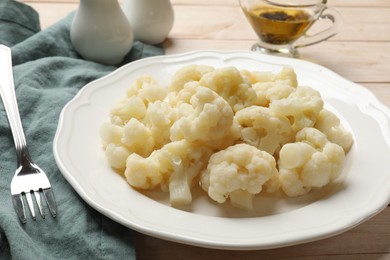 Photo of Tasty cooked cauliflower on white wooden table, closeup