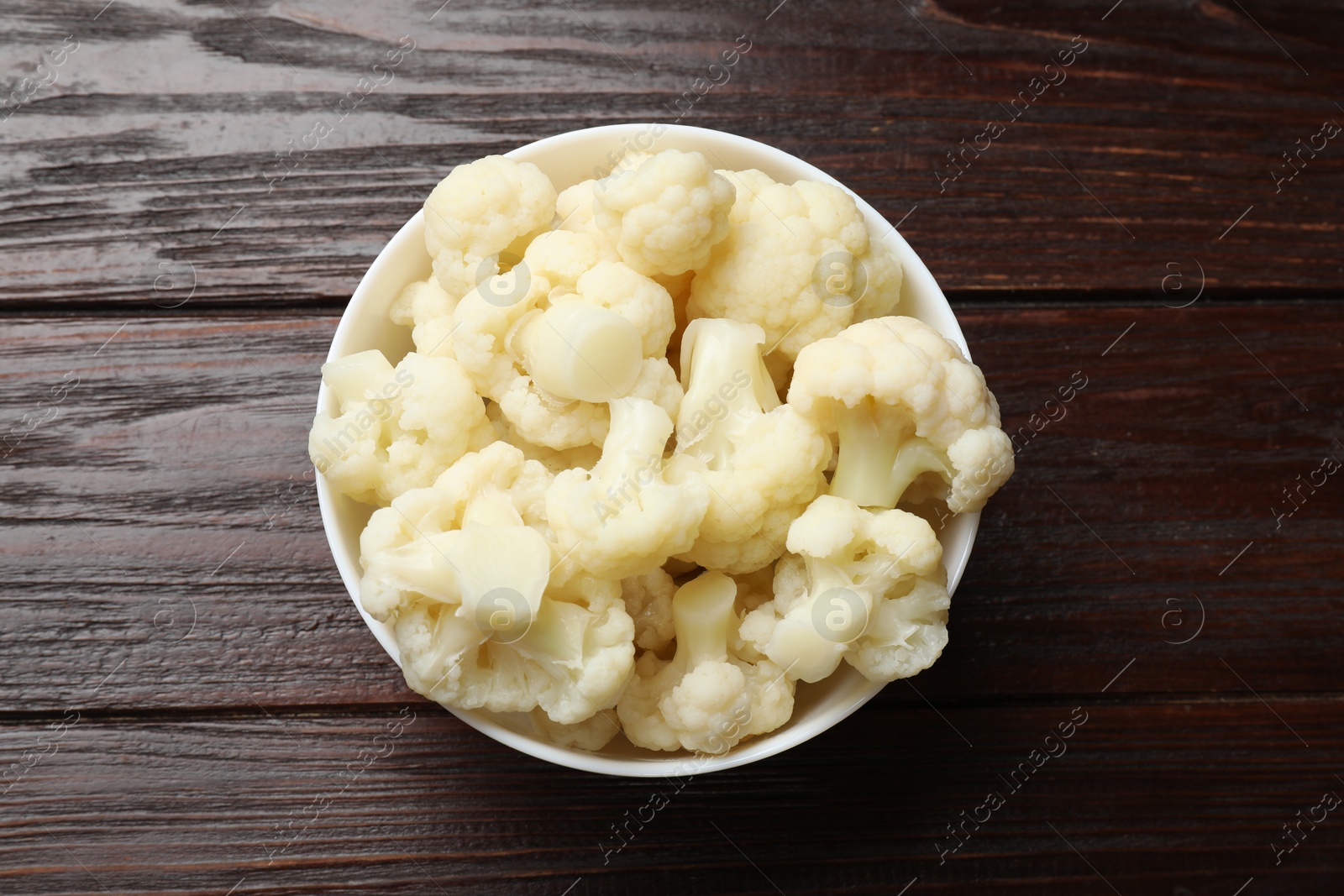 Photo of Tasty cooked cauliflower on wooden table, top view