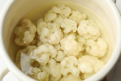 Photo of Cauliflower in white pot with water, closeup