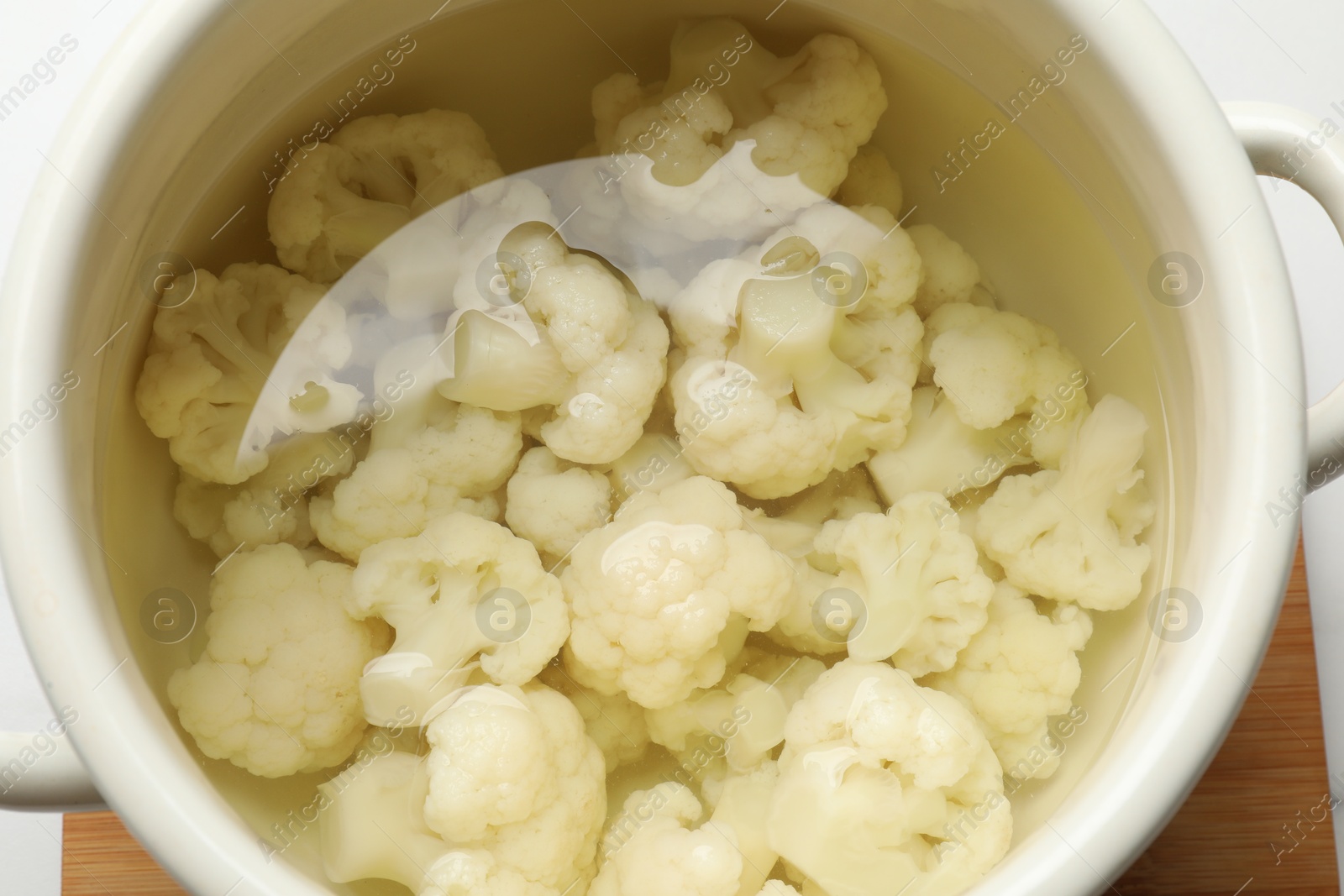 Photo of Cauliflower in pot with water on table, closeup