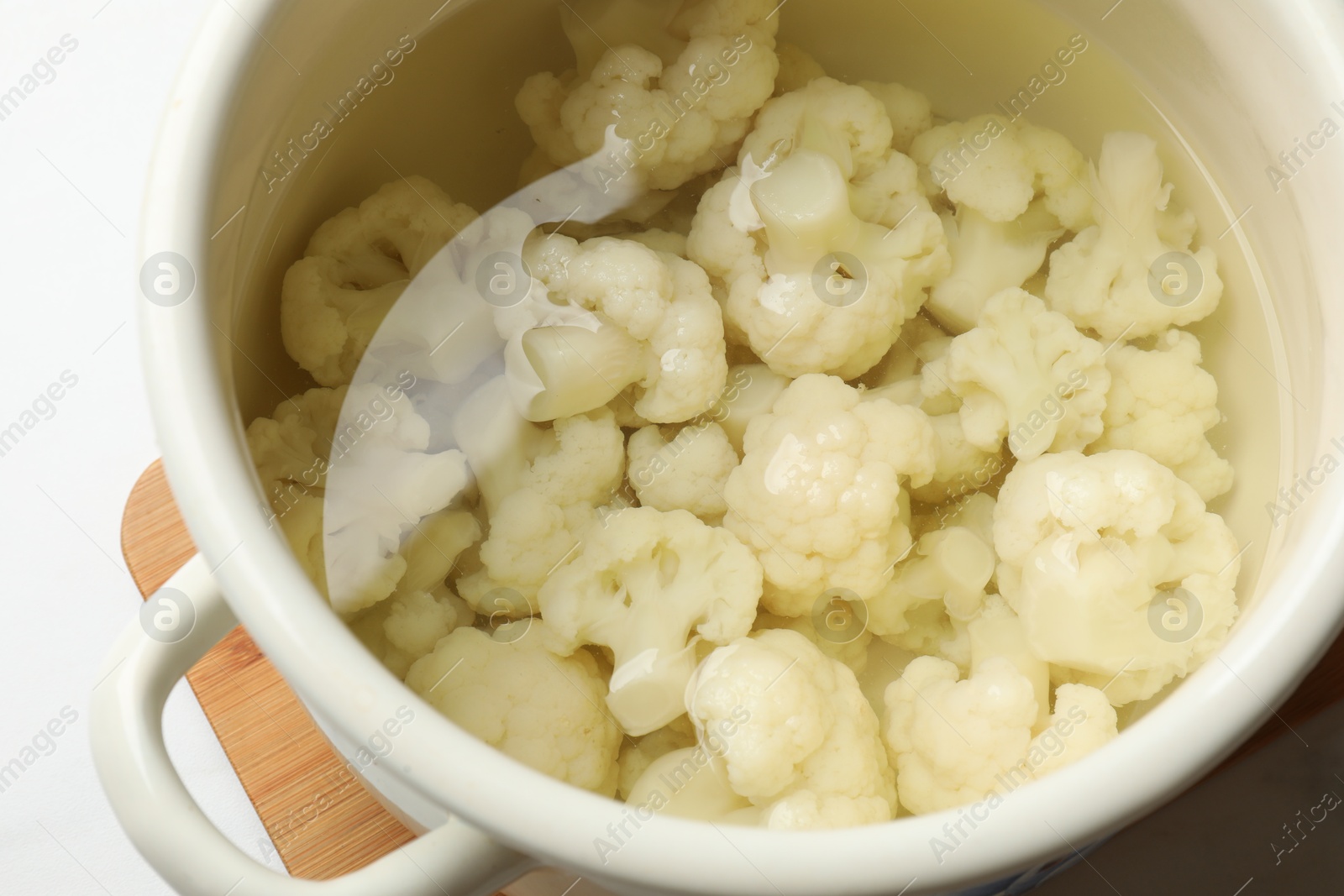 Photo of Cauliflower in pot with water on table, closeup