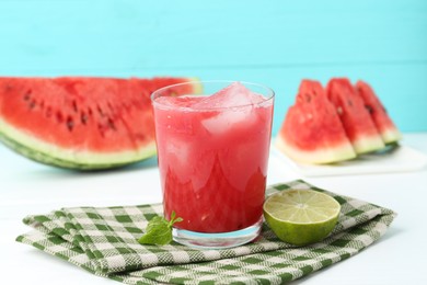 Photo of Tasty watermelon drink in glass, fresh fruits and mint on white table