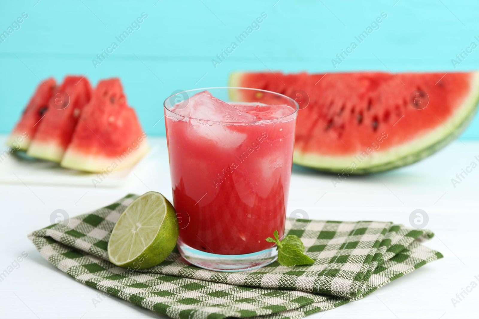 Photo of Tasty watermelon drink in glass, fresh fruits and mint on white table