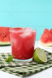 Photo of Tasty watermelon drink in glass, fresh fruits and mint on white table