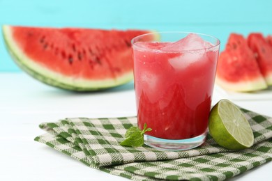 Photo of Tasty watermelon drink in glass, fresh fruits and mint on white table, closeup