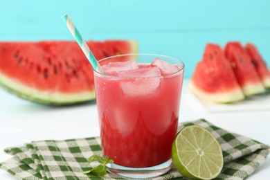 Photo of Tasty watermelon drink in glass, fresh fruits and mint on white table, closeup