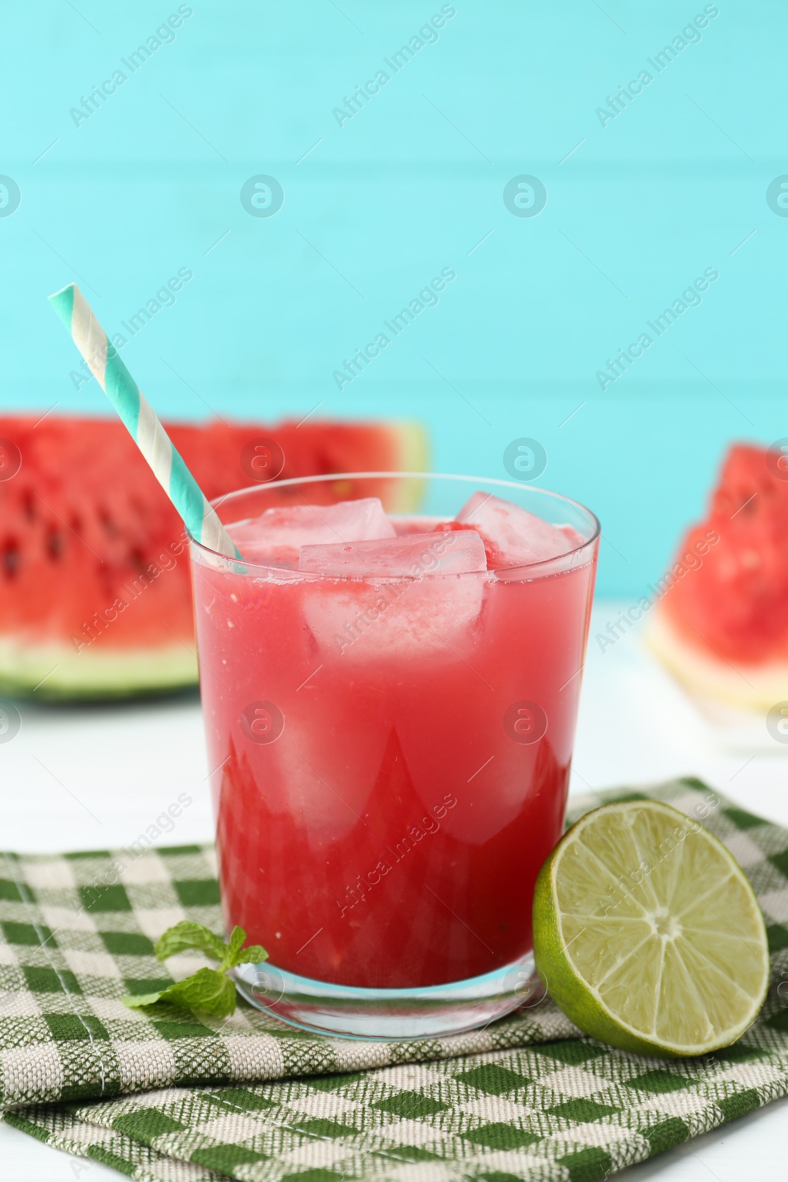 Photo of Tasty watermelon drink in glass, fresh fruits and mint on white table