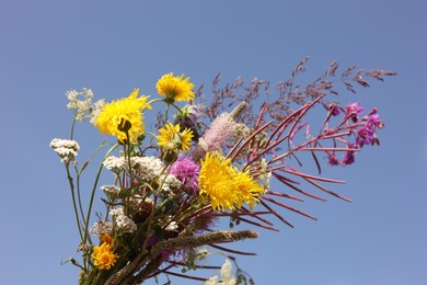 Photo of Holding beautiful bouquet of wild flowers outdoors, closeup