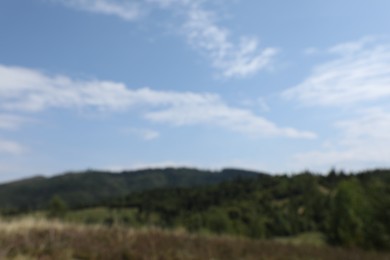 Photo of Blurred view of forest in mountains under blue sky