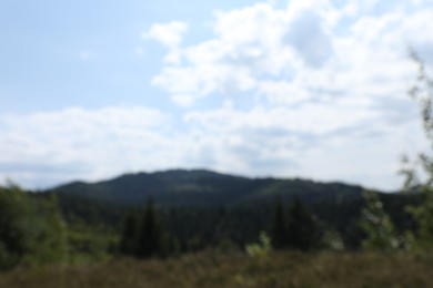 Blurred view of forest in mountains under blue sky