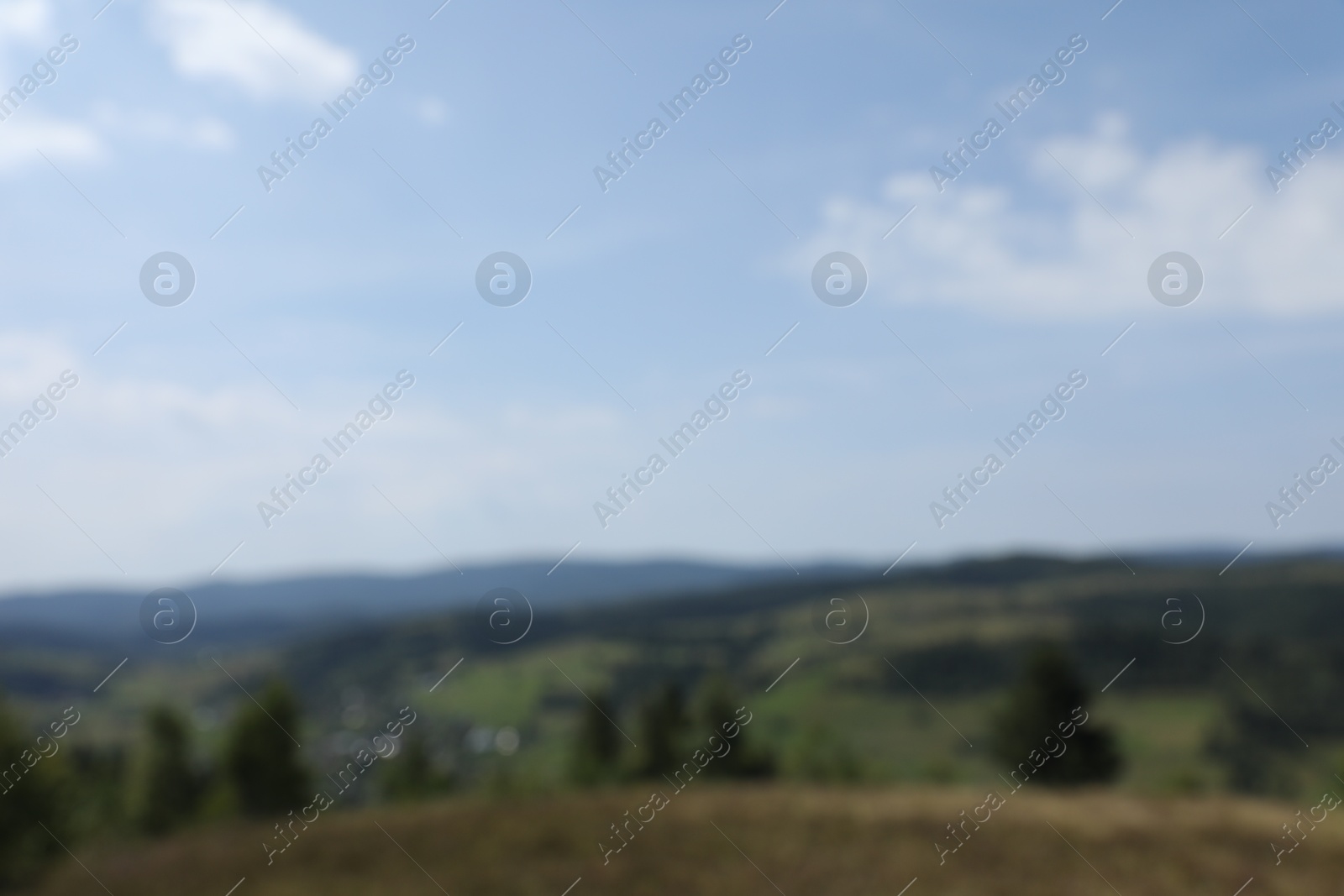 Photo of Blurred view of forest in mountains under blue sky