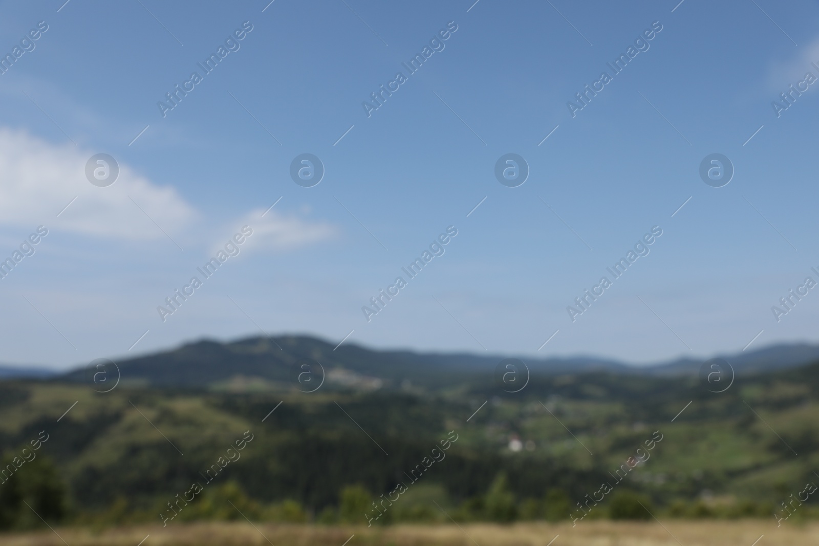 Photo of Blurred view of forest in mountains under blue sky