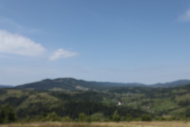 Blurred view of forest in mountains under blue sky