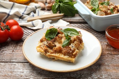 Photo of Tasty baked cauliflower, basil, sauce and tomatoes on wooden table