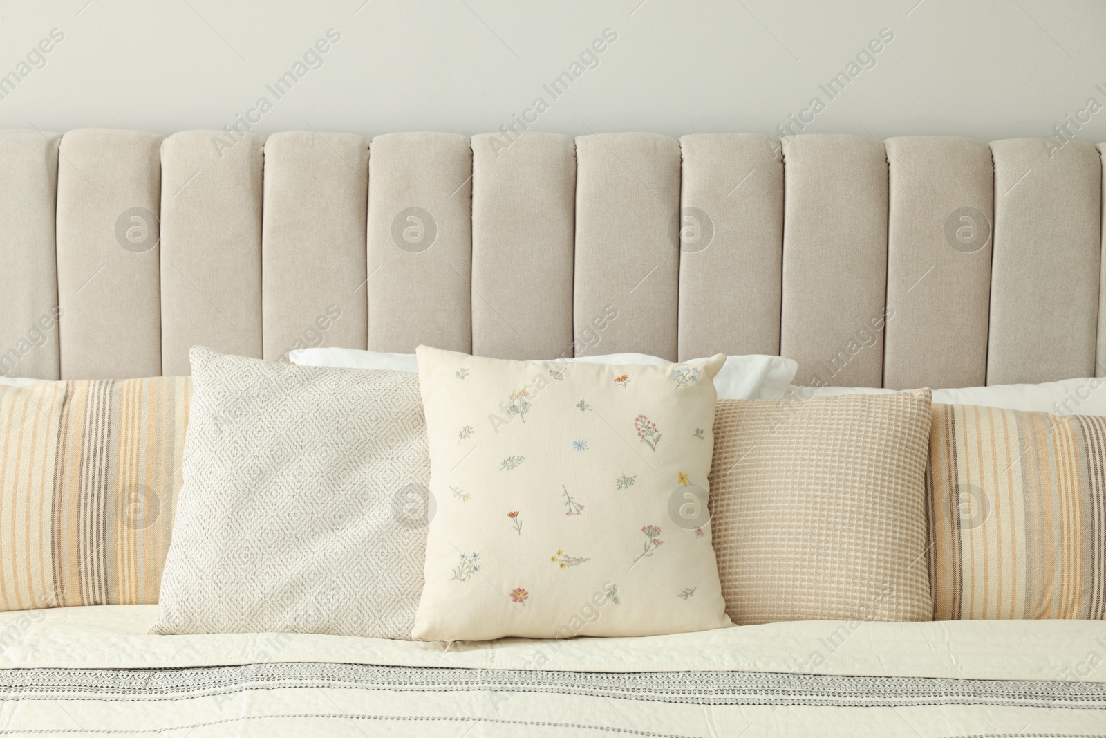 Photo of Many pillows on soft bed in bedroom