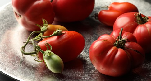 Photo of Different ripe and unripe tomatoes on grey table, closeup