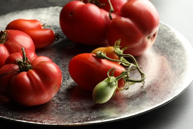 Different ripe and unripe tomatoes on grey table, closeup