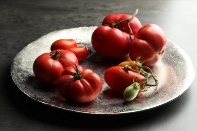 Photo of Different ripe and unripe tomatoes on grey table