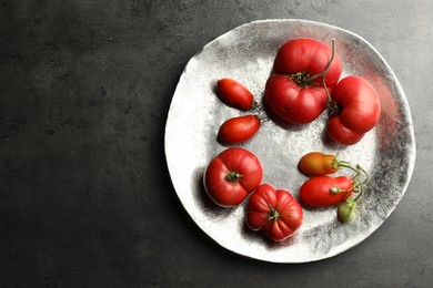 Photo of Different ripe and unripe tomatoes on grey table, top view. Space for text