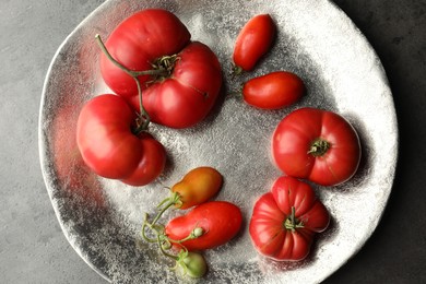 Photo of Different ripe and unripe tomatoes on grey table, top view