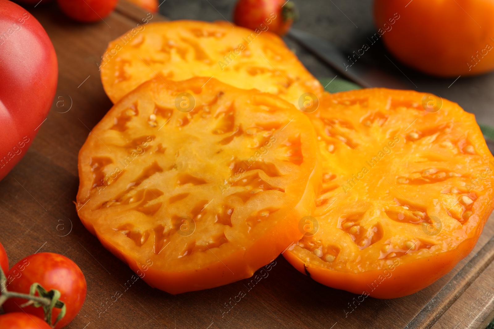 Photo of Cut and whole ripe tomatoes on grey table, closeup