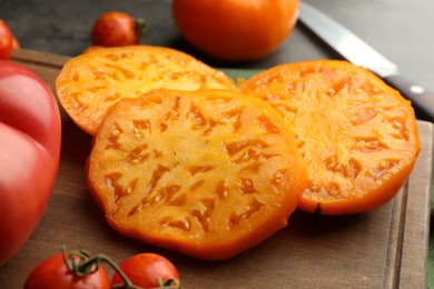 Cut and whole ripe tomatoes on grey table, closeup