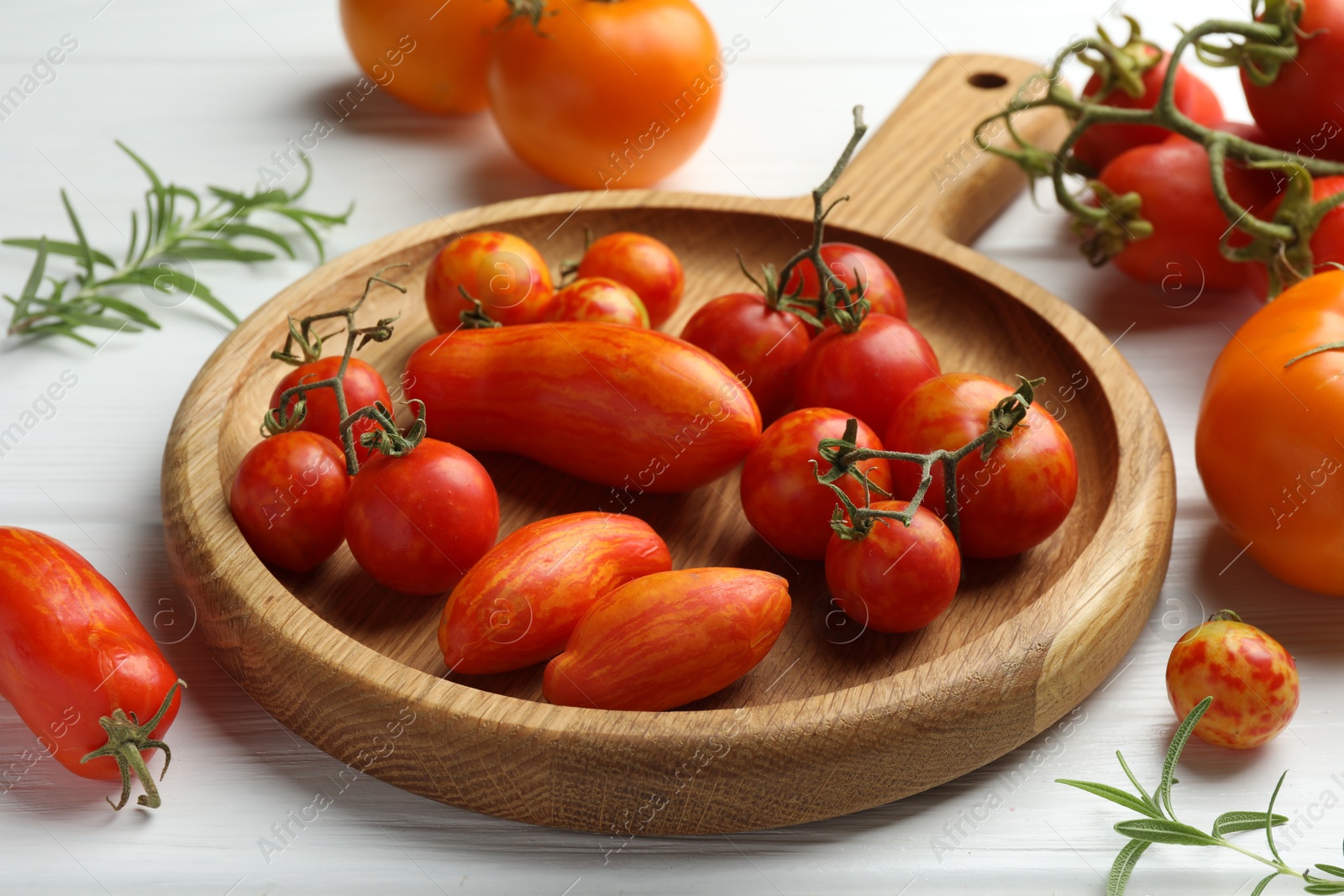 Photo of Different ripe tomatoes on white wooden table