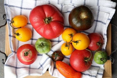 Different ripe and unripe tomatoes on grey table, flat lay