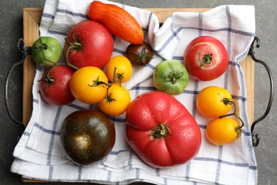 Photo of Different ripe and unripe tomatoes on grey table, flat lay