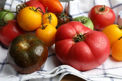 Different ripe and unripe tomatoes on table, closeup