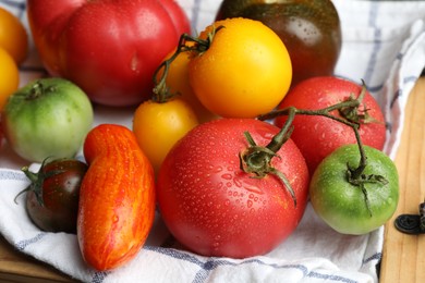 Different ripe and unripe tomatoes on table, closeup