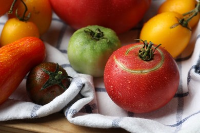 Different ripe and unripe tomatoes on table, closeup