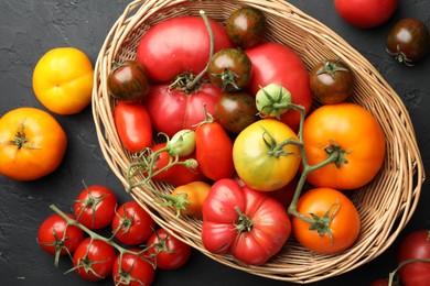 Photo of Different ripe and unripe tomatoes on grey textured table, flat lay