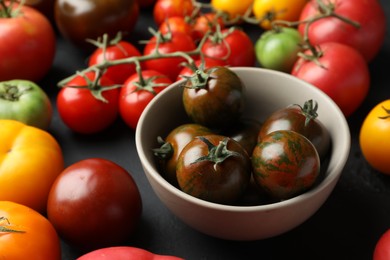 Many different fresh tomatoes on grey table, closeup