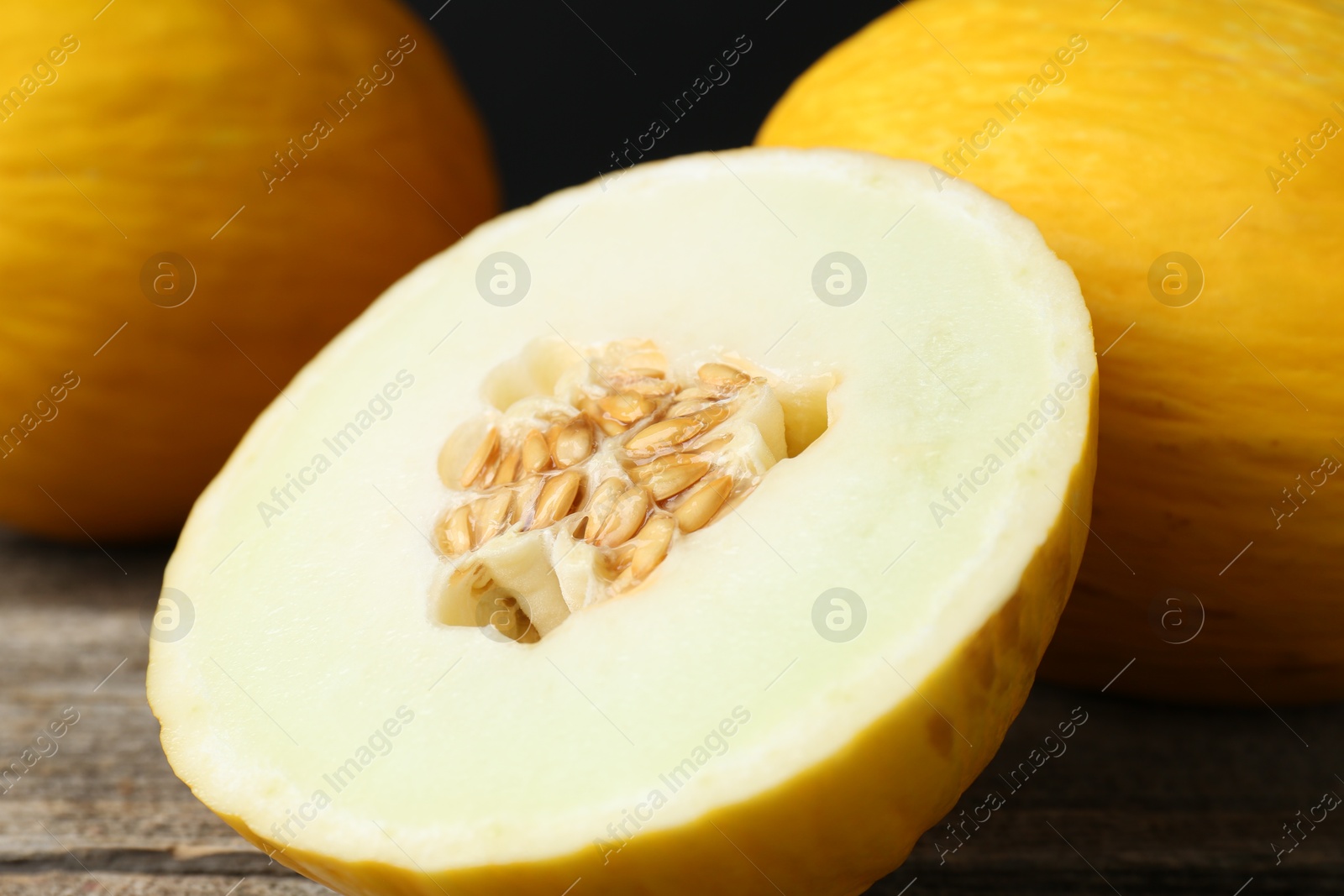 Photo of Fresh ripe melons on wooden table, closeup