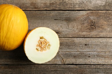 Photo of Fresh ripe melons on wooden table, top view. Space for text